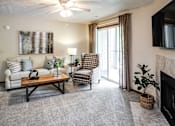 Thumbnail 48 of 70 - A living room with a couch, chair, and a fireplace. at The Pointe, LaVista, 68128