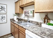 Thumbnail 58 of 70 - A kitchen with a sink and a white dishwasher. at The Pointe, LaVista, NE