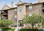 Thumbnail 12 of 70 - A large brick apartment building with a tree in front. at The Pointe, LaVista, Nebraska