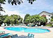 Thumbnail 22 of 70 - A pool surrounded by trees and chairs. at The Pointe, LaVista, Nebraska