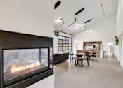 Thumbnail 19 of 36 - A modern living room with a fireplace and a dining area.