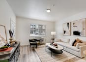 Thumbnail 8 of 36 - A modern living room with a white sofa, a black coffee table, and two framed artworks on the wall.