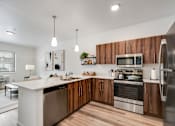 Thumbnail 1 of 36 - A modern kitchen with wooden cabinets and stainless steel appliances.
