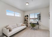 Thumbnail 23 of 36 - A living room with a white couch and a green chair.
