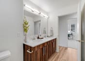 Thumbnail 6 of 36 - A bathroom with a white tub and a white sink with brown cabinets.