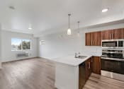 Thumbnail 32 of 36 - A modern kitchen with wooden cabinets and stainless steel appliances.