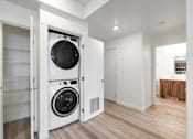 Thumbnail 3 of 36 - A white washing machine is in a white cabinet.