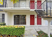 Thumbnail 62 of 133 - A white building with a red door and a black metal staircase.