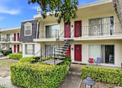 Thumbnail 107 of 133 - Apartment building with red doors and a tree in front.