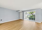 Thumbnail 68 of 133 - A room with light blue walls and wooden flooring with a sliding glass door.