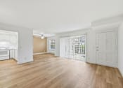 Thumbnail 104 of 133 - A spacious room with wooden flooring and white walls.
