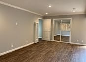Thumbnail 22 of 37 - A room with wooden flooring and a white door.