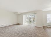 Thumbnail 117 of 133 - A room with a carpeted floor and a sliding door.