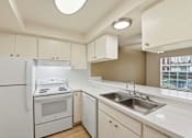 Thumbnail 79 of 133 - A kitchen with white appliances and cabinets.