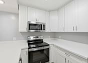 Thumbnail 69 of 133 - A kitchen with white cabinets and a black oven.