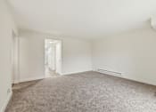 Thumbnail 114 of 133 - A large empty room with carpeted floor and white walls.