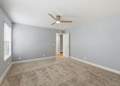 Thumbnail 70 of 133 - A room with a ceiling fan and carpeted floor.