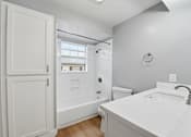 Thumbnail 75 of 133 - A white bathroom with a toilet, sink, and bathtub.