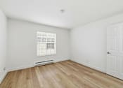 Thumbnail 100 of 133 - A room with a white door and a window with blinds.