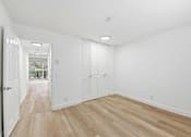 Thumbnail 92 of 133 - A room with white walls and wooden flooring.