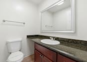 Thumbnail 124 of 133 - A white toilet sits next to a sink in a bathroom.