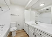 Thumbnail 94 of 133 - A white bathroom with a toilet, sink, and bathtub.
