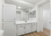 Thumbnail 105 of 133 - A white bathroom with a toilet, sink, and mirror.
