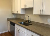 Thumbnail 45 of 62 - a kitchen with a sink and white cabinets