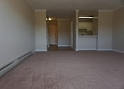 Thumbnail 22 of 30 - A room with a carpeted floor and a doorway leading to another room.