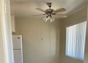 Thumbnail 31 of 33 - A room with a ceiling fan and a white refrigerator.
