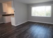 Thumbnail 11 of 17 - an empty living room with wood floors and a window