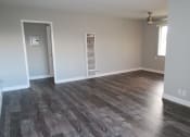 Thumbnail 8 of 17 - a living room with a hard wood floor and white walls