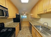 Thumbnail 10 of 22 - A kitchen with wooden cabinets and granite countertops.