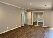 Thumbnail 27 of 37 - A room with a wooden floor and a white door.