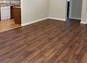 Thumbnail 10 of 22 - A kitchen with wooden floors and white walls.