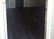 Thumbnail 18 of 31 - A room with a dark floor and white walls.