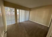 Thumbnail 23 of 23 - A room with a carpeted floor and a sliding glass door.