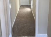 Thumbnail 23 of 26 - a hallway with a carpeted floor and a white door