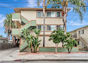 Thumbnail 9 of 14 - A two-story house with a green staircase on the side.