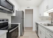 Thumbnail 90 of 92 - A kitchen with white cabinets and a black countertop.