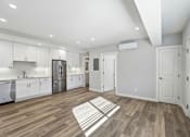 Thumbnail 59 of 67 - A kitchen with white cabinets and a wooden floor.