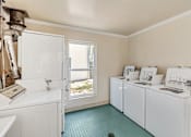 Thumbnail 28 of 43 - A laundry room with a washer and dryer in it.