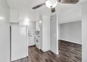 Thumbnail 31 of 40 - A kitchen with white appliances and wood flooring.