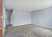 Thumbnail 32 of 55 - A room with a carpeted floor and a door on the left.