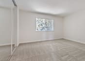 Thumbnail 42 of 52 - A room with a carpeted floor and a window with blinds.