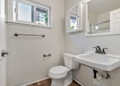 Thumbnail 44 of 52 - A white toilet sits next to a white sink in a bathroom.