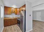 Thumbnail 7 of 17 - A kitchen with wooden cabinets and a stainless steel refrigerator.