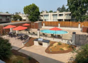 Thumbnail 33 of 37 - a pool and tables with umbrellas in an apartment yard