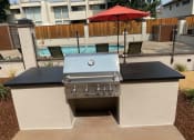 Thumbnail 36 of 37 - a gas grill on a patio next to a pool
