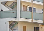 Thumbnail 9 of 36 - a balcony of a building with stairs and a glass door